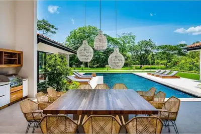 a dining room with a wooden table and chairs and a swimming pool at 8bd Villa ✪ Top Luxury & Exclusive Villa ✪ up to 24 guests in San José Pinilla