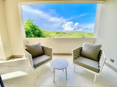 two chairs and a table in a room with a large window at ✰Upscale 3Bdr condo✰ Incredible amenities ✰Fast wifi in Tamarindo
