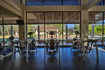 a gym with a bunch of exercise equipment in a room at Private Pool Townhouse with Partial Ocean View - Aromo - Reserva Conchal in Playa Conchal