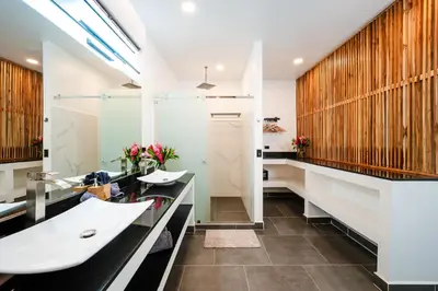 a bathroom with two sinks and a shower at House of Nomad - Adults only in Tamarindo