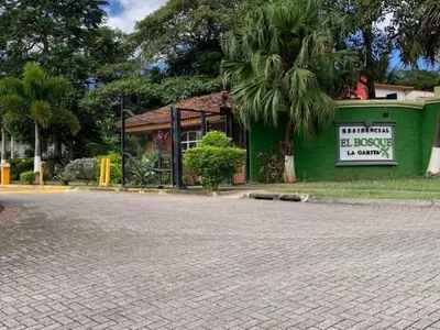 a building with a sign on the side of a street at Casa Bosque GuestHouse & Car Rental - Free SJO Airport Shuttle in Desamparados