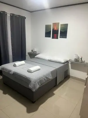 a bedroom with a bed with two towels on it at Casa Bosque GuestHouse & Car Rental - Free SJO Airport Shuttle in Desamparados