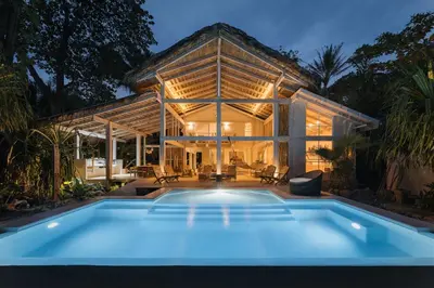 a house with a blue pool in front of it at Casa Arena Beachfront Property in Santa Teresa Beach