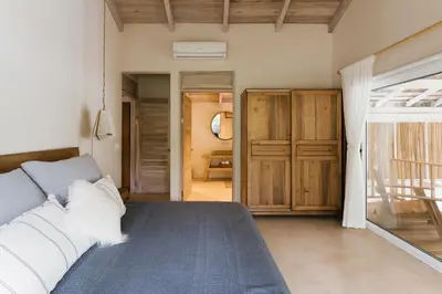 a bedroom with a bed and a door to a bathroom at Casa Arena Beachfront Property in Santa Teresa Beach