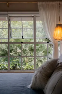 a bedroom with a large window and a bed with at Casa Arena Beachfront Property in Santa Teresa Beach