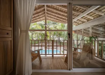 a room with a sliding glass door leading to a pool at Casa Arena Beachfront Property in Santa Teresa Beach