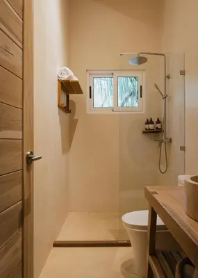 a bathroom with a shower and a toilet and a window at Casa Arena Beachfront Property in Santa Teresa Beach