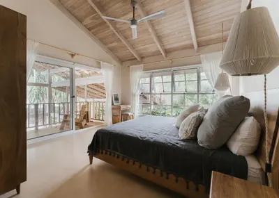 a bedroom with a bed and a large window at Casa Arena Beachfront Property in Santa Teresa Beach