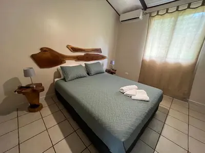 a bedroom with a bed with two towels on it at Casa Tropical Playa Grande in Cuajiniquil