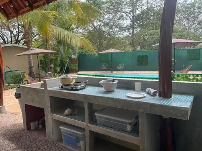 a table with food on it next to a pool at Casa Tropical Playa Grande in Cuajiniquil