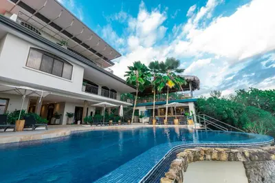 a swimming pool in front of a building at Marala Hotel in Esterillos