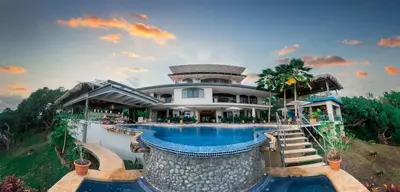 a large house with a swimming pool in front of it at Marala Hotel in Esterillos