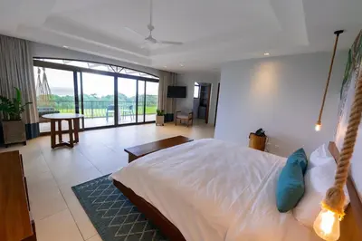 a bedroom with a bed and a living room at Marala Hotel in Esterillos