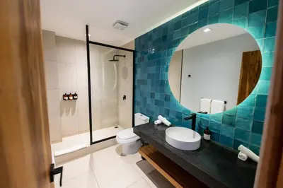 a bathroom with a sink and a toilet and a mirror at Marala Hotel in Esterillos