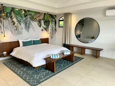 a bedroom with a large bed and a mirror at Marala Hotel in Esterillos