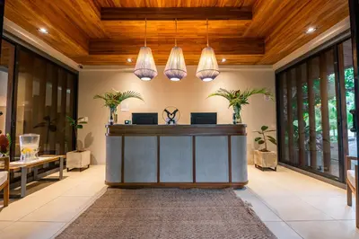 an office lobby with a reception desk and potted plants at Marala Hotel in Esterillos