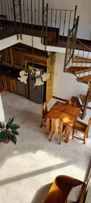 a living room with a wooden bench and a staircase at La Torre Azul in Alajuela City