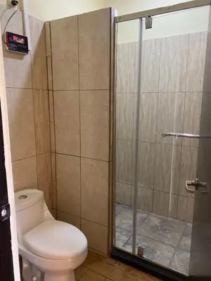 a bathroom with a toilet and a glass shower at Villa Garita Inn in La Garita