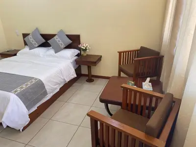 a bedroom with a bed and two chairs at Villa Garita Inn in La Garita