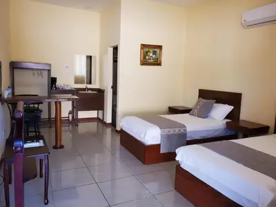 a hotel room with two beds and a desk at Villa Garita Inn in La Garita