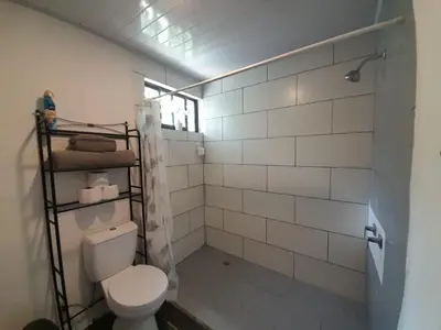 a bathroom with a white toilet and a window at Mi casita in Montezuma