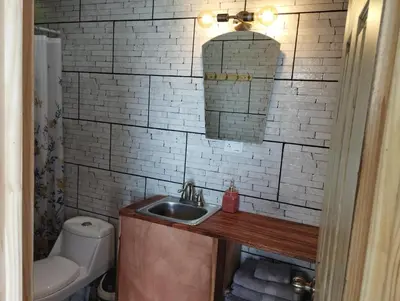 a bathroom with a sink and a white brick wall at Siary Aparment con vista 3 in Monteverde Costa Rica