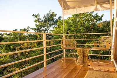 a deck with two chairs and an umbrella at Quimera Glamping in Pacuar