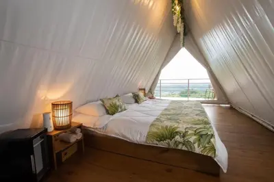 a bedroom with a bed in a tent with a window at Quimera Glamping in Pacuar