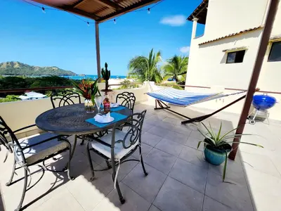 a patio with a table and chairs on a balcony at Amazing Oceanview Private Villa Rooftop Terrace Walk to Beach in Coco