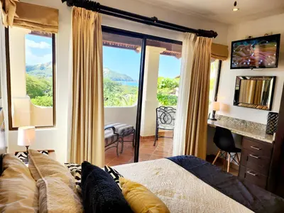 a bedroom with a bed and a large window with a view at Amazing Oceanview Private Villa Rooftop Terrace Walk to Beach in Coco