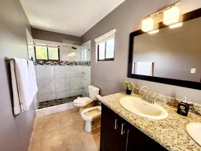 a bathroom with a sink and a toilet and a mirror at Amazing Oceanview Private Villa Rooftop Terrace Walk to Beach in Coco