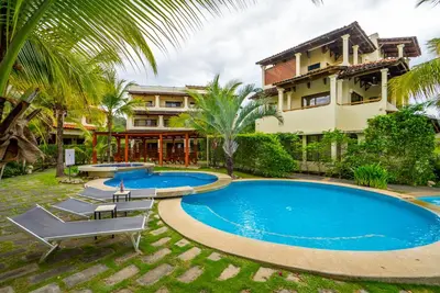 a swimming pool in front of a building with a resort at Amazing Oceanview Private Villa Rooftop Terrace Walk to Beach in Coco