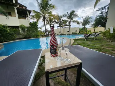 a table with wine glasses on it next to a pool at Amazing Oceanview Private Villa Rooftop Terrace Walk to Beach in Coco