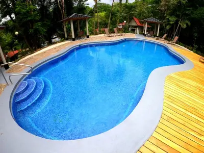 a swimming pool with blue water in a resort at El Sueno Tropical in Carrillo