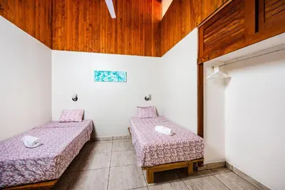 two beds in a room with wooden ceilings at El Sueno Tropical in Carrillo