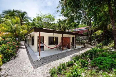 a small house in the middle of a garden at El Sueno Tropical in Carrillo