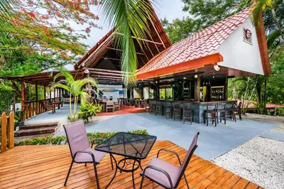 an outdoor deck with chairs and a bar at El Sueno Tropical in Carrillo