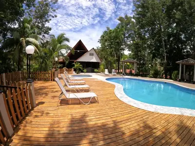 a deck with chairs and a swimming pool at El Sueno Tropical in Carrillo