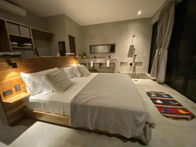 a bedroom with a large bed and a television at CASA BÚHO in Santa Teresa Beach