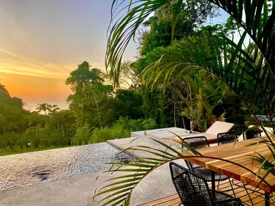 a pool with chairs and a table and water at CASA BÚHO in Santa Teresa Beach