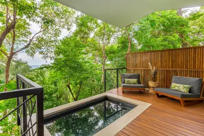 a deck with a bench and a chair on a balcony at NAIA OCEANVIEW STUDIO in Carmen