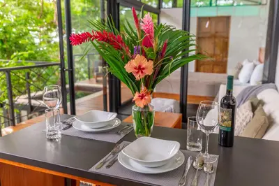 a table with plates and a vase of flowers on it at NAIA OCEANVIEW STUDIO in Carmen