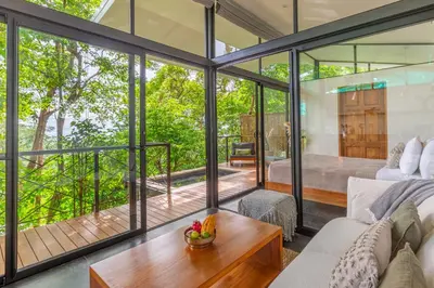 a glass house with a living room and a bedroom at NAIA OCEANVIEW STUDIO in Carmen