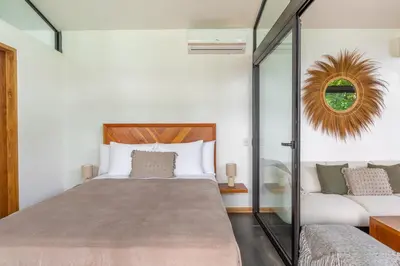a bedroom with a bed and a mirror at NAIA OCEANVIEW STUDIO in Carmen