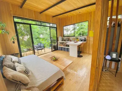 a bedroom with a bed and a desk in a room at CASA BUHO and COZY JUNGLE CABANA in Santa Teresa Beach