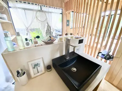 a bathroom with a black sink and a window at CASA BUHO and COZY JUNGLE CABANA in Santa Teresa Beach