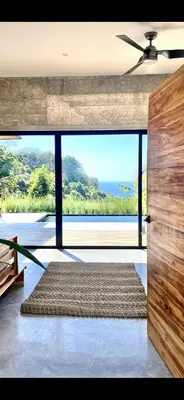 a living room with a large window and a large rug at CASA BUHO and COZY JUNGLE CABANA in Santa Teresa Beach
