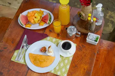a wooden table with two plates of food on it at Tree Houses Hotel Costa Rica in Florencia
