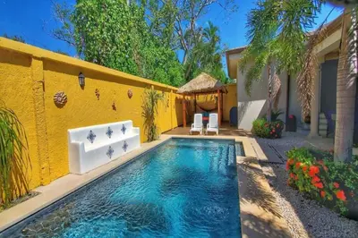 a swimming pool in front of a yellow house at Casa Cocoa - 3 Br Home In Playa Langosta in Tamarindo