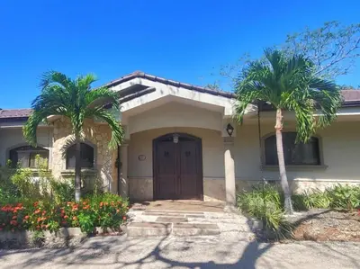 a house with two palm trees in front of it at Casa Cocoa - 3 Br Home In Playa Langosta in Tamarindo